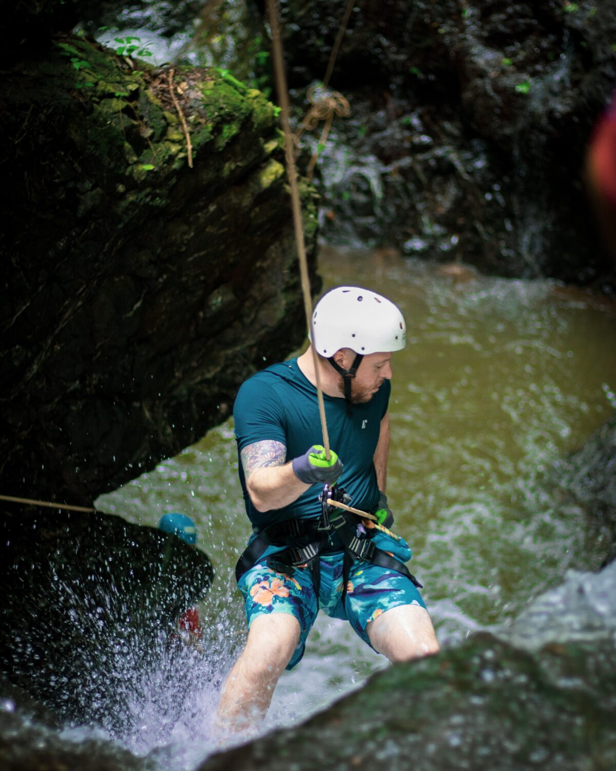 Guest rappelling down a jungle waterfall at Vista Los Sueños canyoning tour